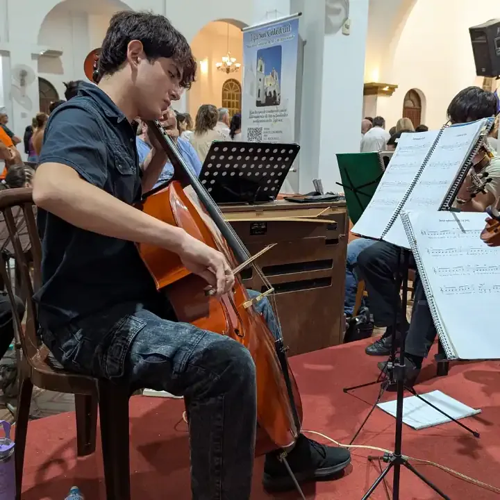 Estudiante del conservatorio Santa Cecilia ejecutando un instrumento (Violoncello) prestado proveido por el conservatorio